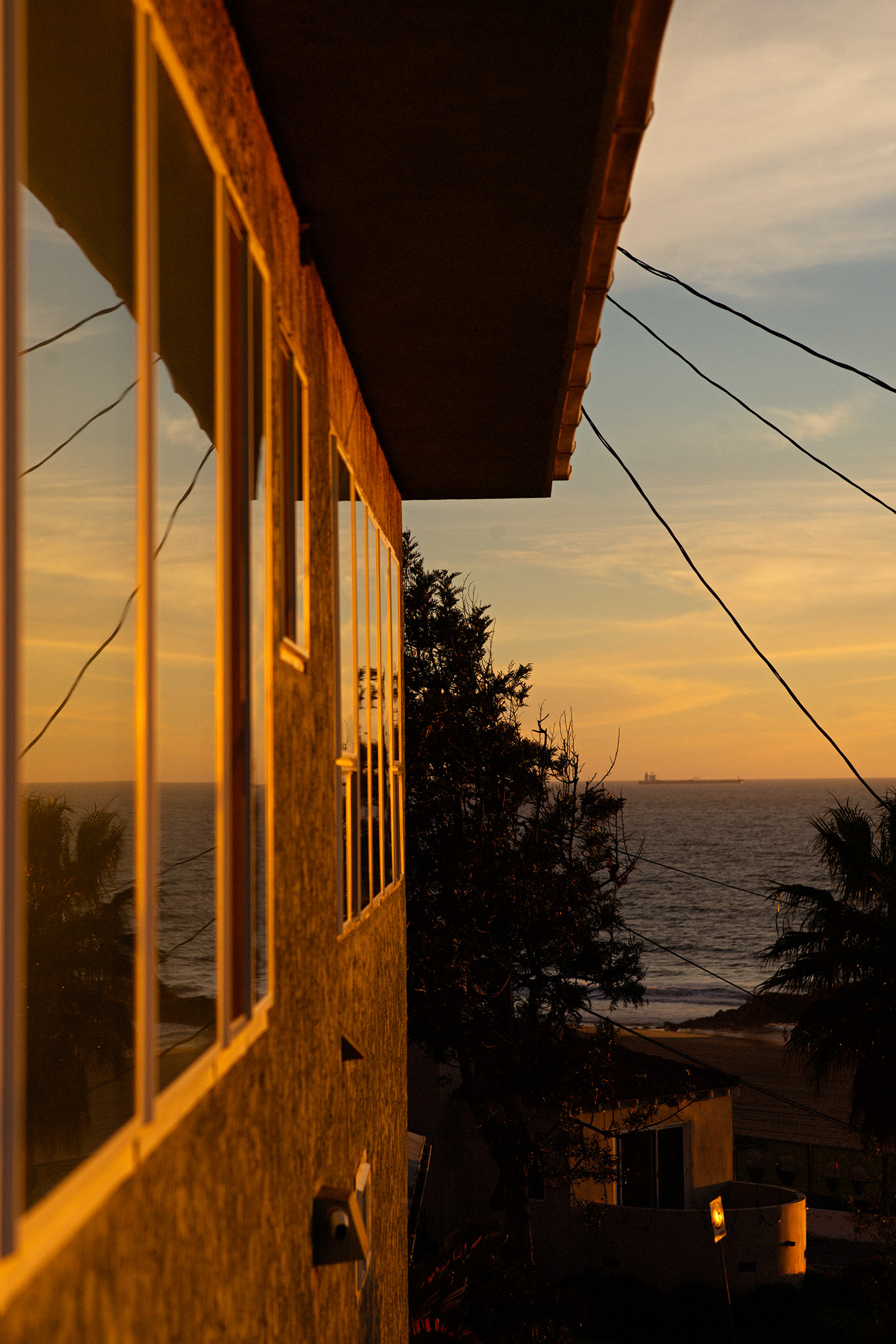 view from a window of the sunset hitting the side of a building