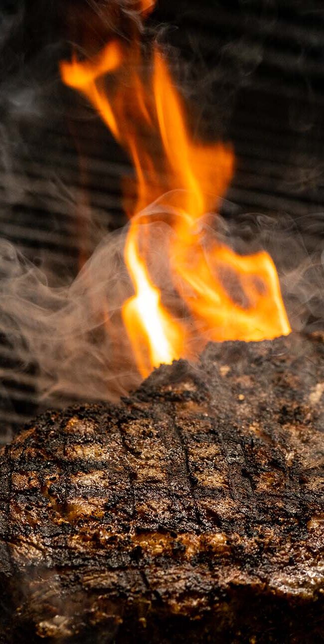 Steak being fired onto the grilled to cook.