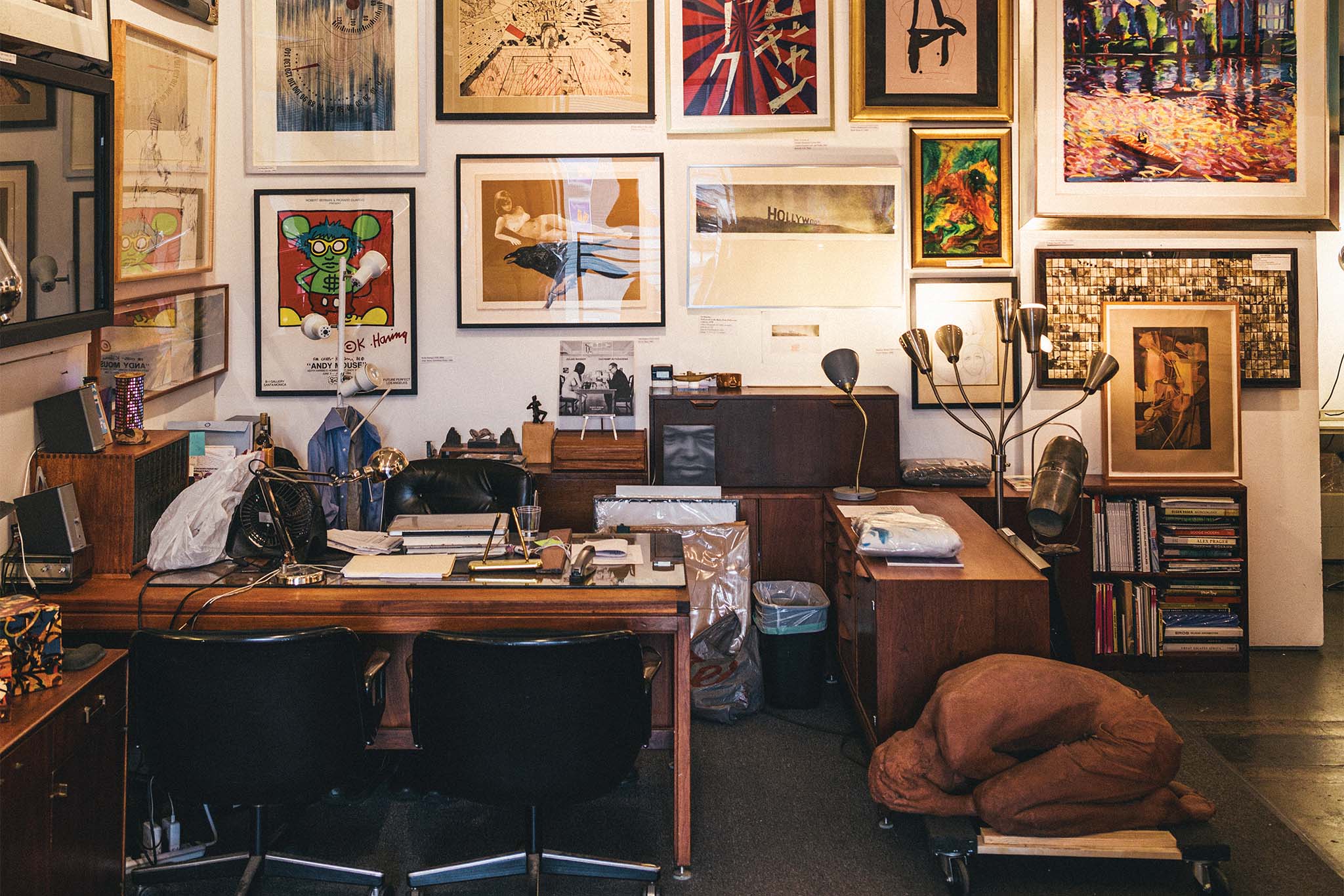 a room with a desk and chairs and art on the wall